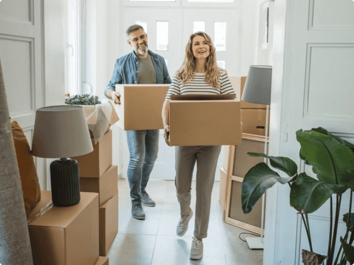 Couple moving boxes inside a house