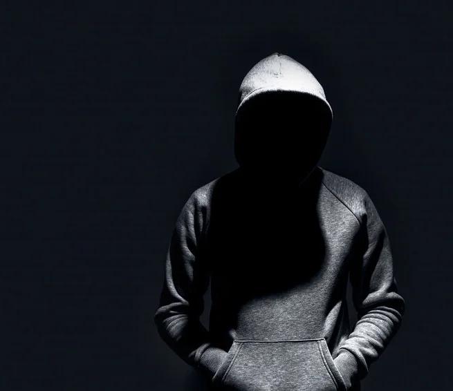 Man with concealed face wearing a dark colored hooded sweater